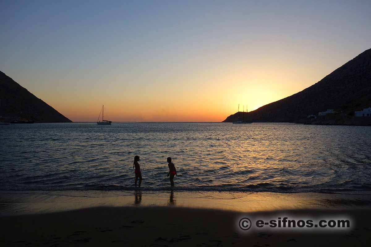 Kinder spielen am Strand bei Sonnenuntergang